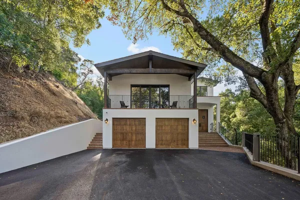front view of a house with a yard and an trees