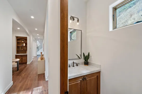 a bathroom with a toilet sink a mirror and vanity