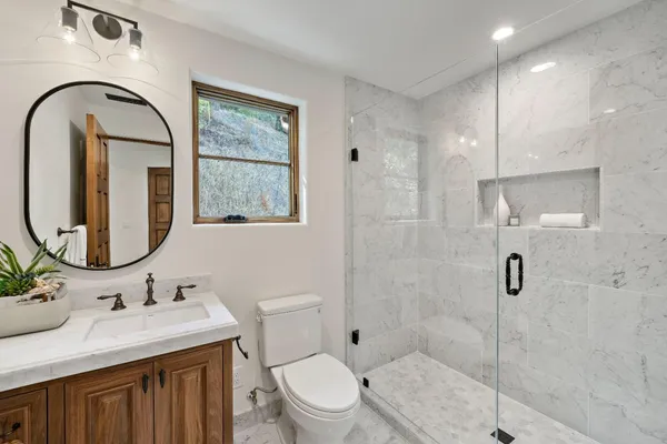 a bathroom with a bathtub a mirror a sink and a large mirror