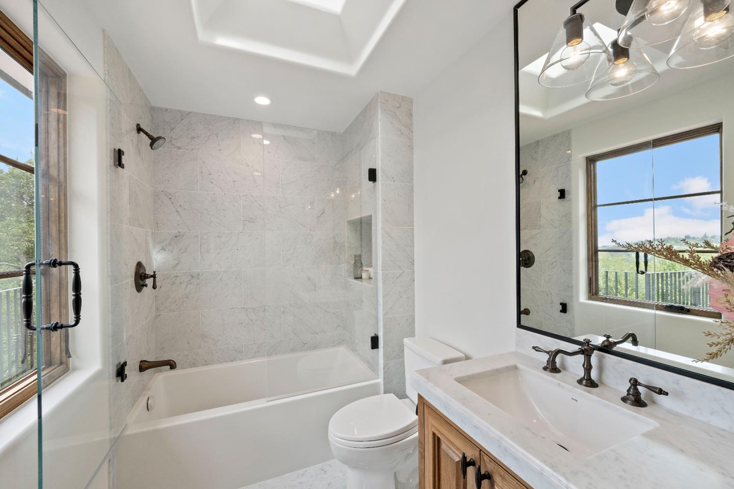15269 Bohlman Road Saratoga, CA 95070 - Photo 49 of 68 a bathroom with a bathtub a mirror a sink and a large mirror