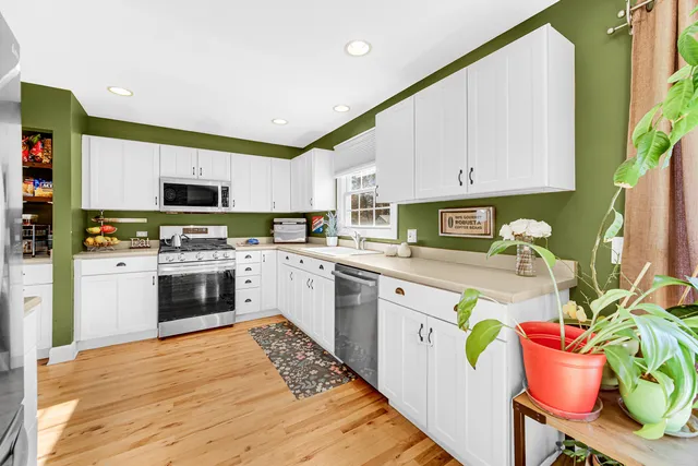 a kitchen with kitchen island granite countertop a stove top oven microwave and cabinets