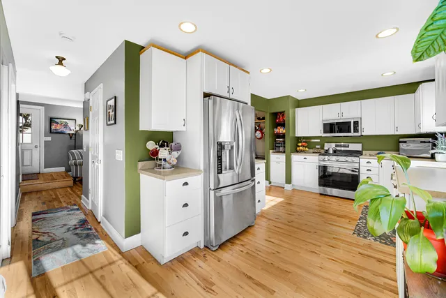 a kitchen with granite countertop a refrigerator and a stove top oven