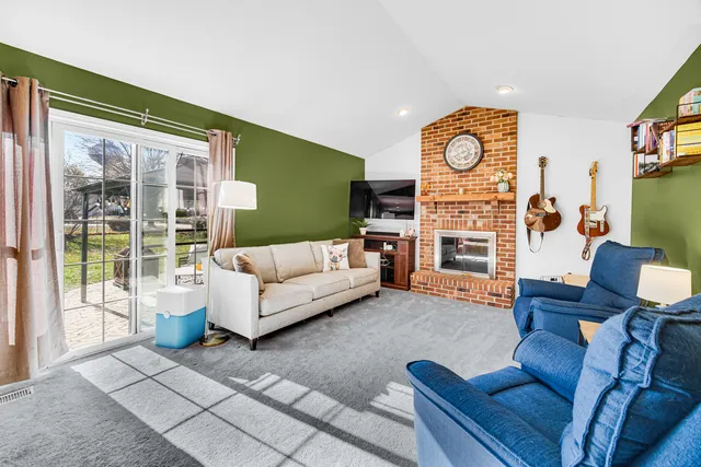 a living room with fireplace furniture and a large window
