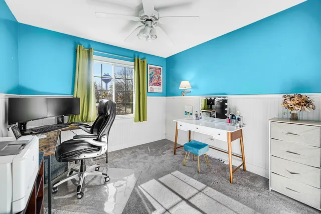 a view of a workspace with furniture and a window