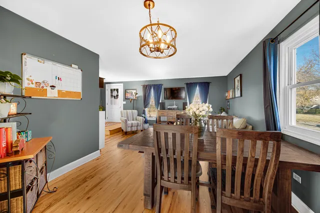 a view of a dining room with furniture a chandelier and wooden floor
