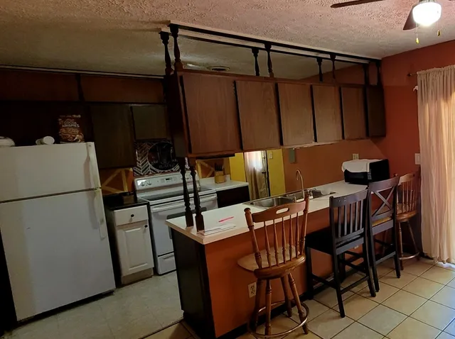 a kitchen with a refrigerator a table and chairs