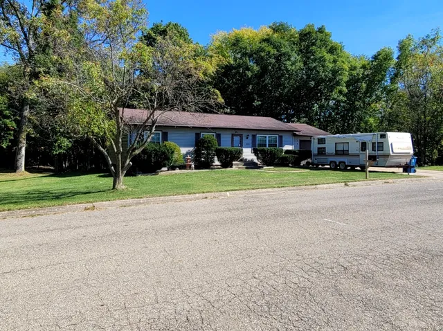 a front view of a house with a yard and trees