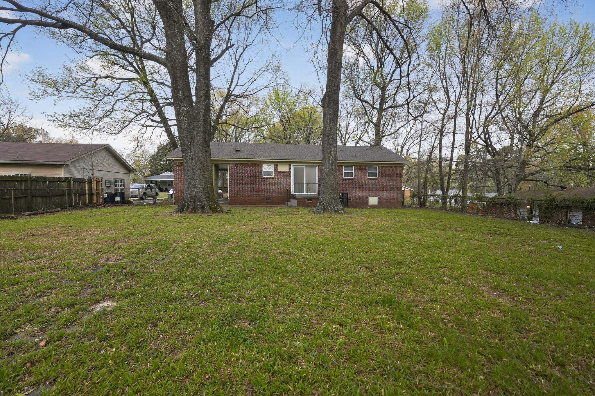 3150 Parham Street Memphis, TN 38127 - Photo 12 of 33 a view of a tree in front of a brick house with a big yard