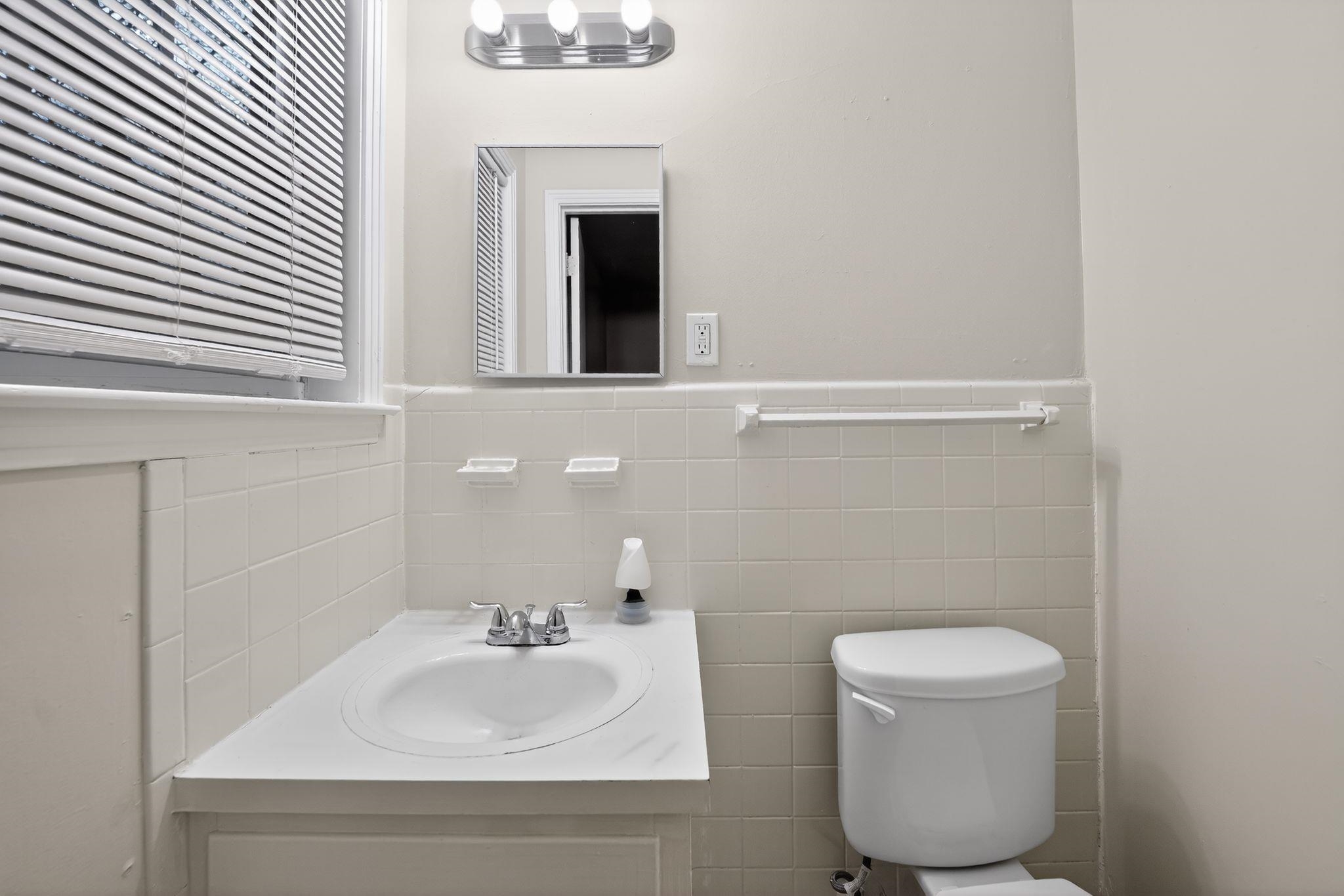 3150 Parham Street Memphis, TN 38127 - Photo 30 of 33 a bathroom with a toilet sink and mirror