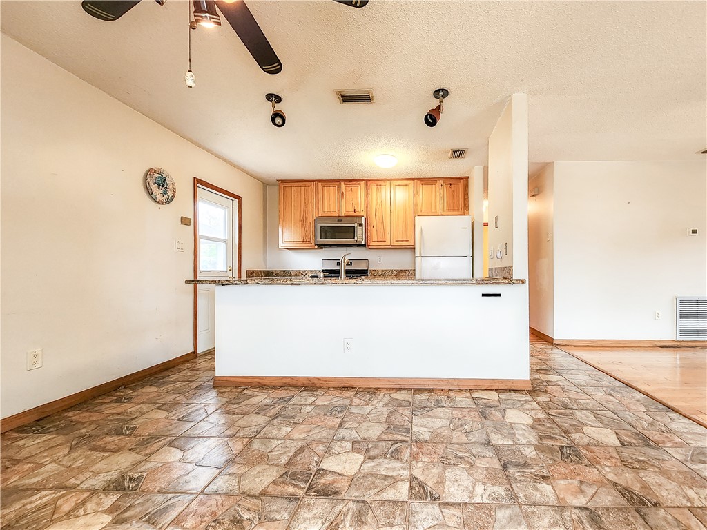 a view of kitchen with granite countertop cabinets and a sink