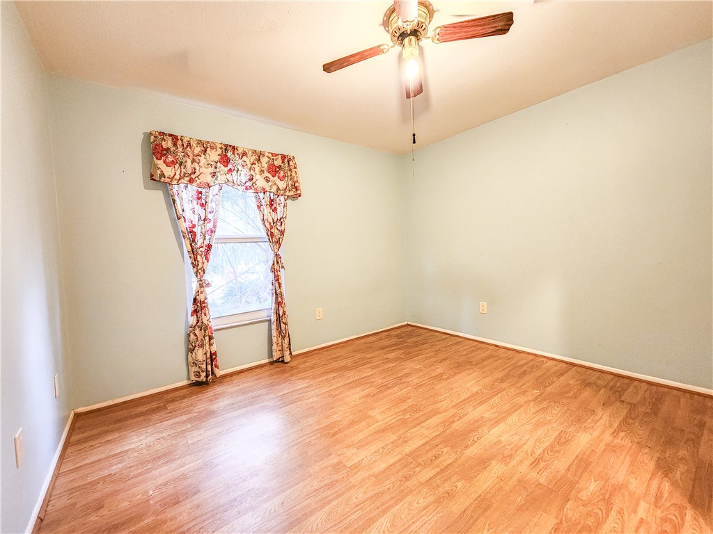 233 13th Street Southwest Vero Beach, FL 32962 - Photo 12 of 20 an empty room with a ceiling fan and wooden floor