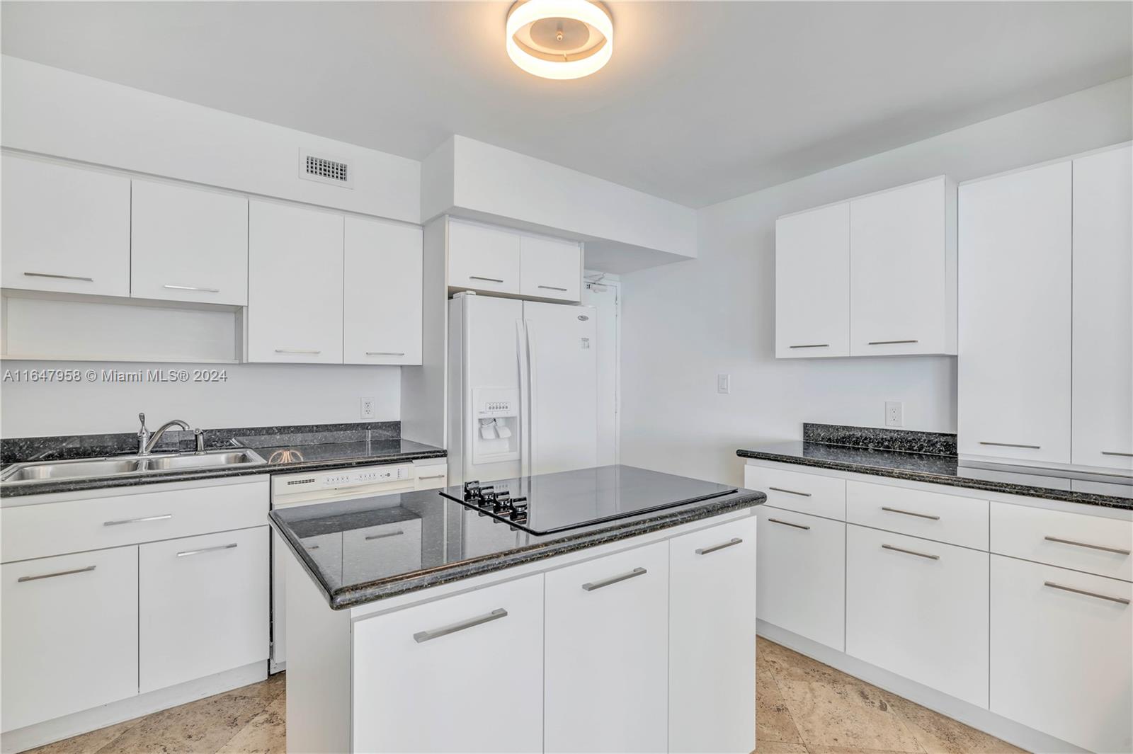 5151 Collins Avenue, Unit 1627 Miami Beach, FL 33140 - Photo 13 of 28 a kitchen with granite countertop a sink cabinets and stainless steel appliances