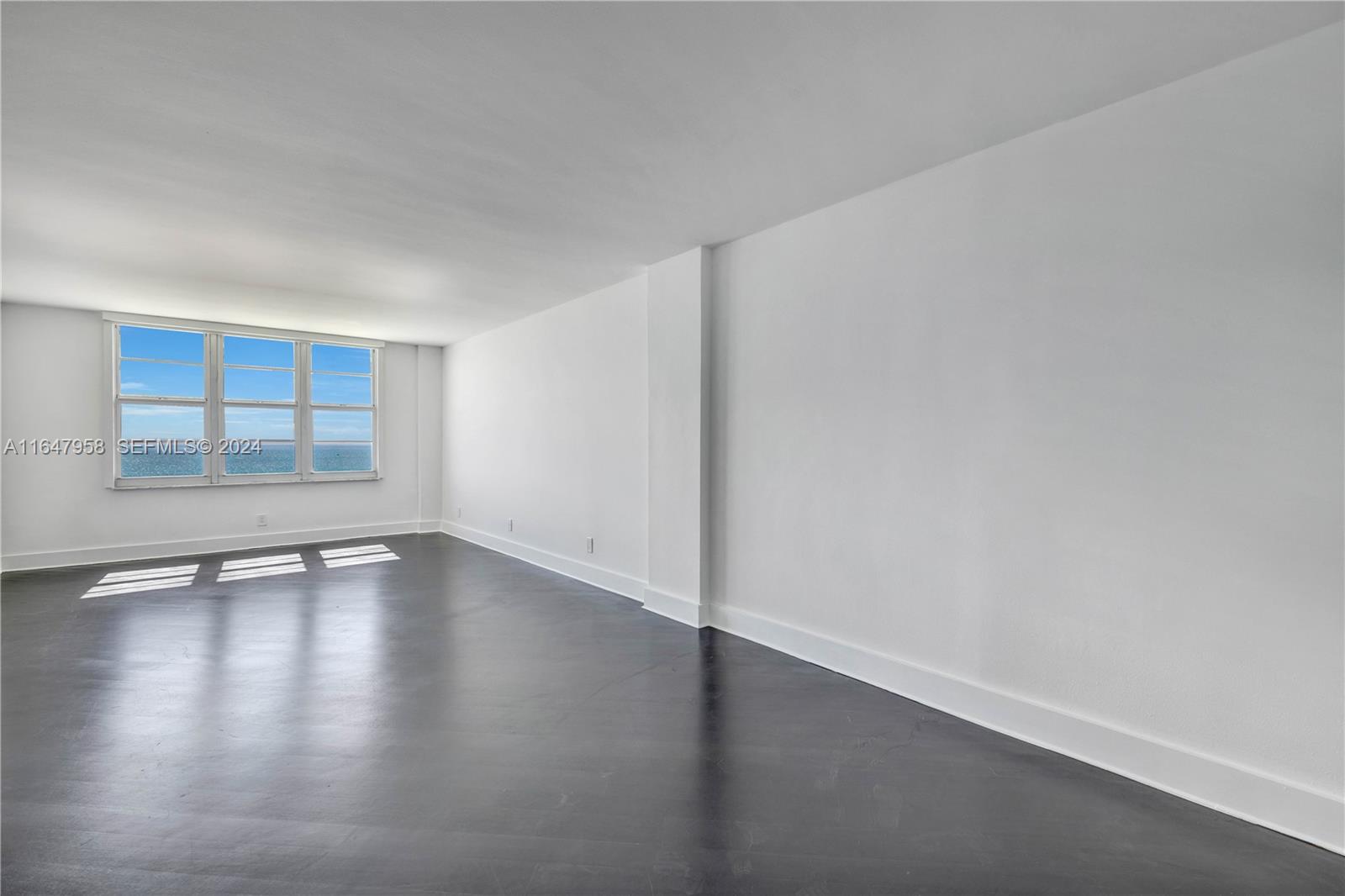 5151 Collins Avenue, Unit 1627 Miami Beach, FL 33140 - Photo 20 of 28 a view of an empty room with wooden floor and window