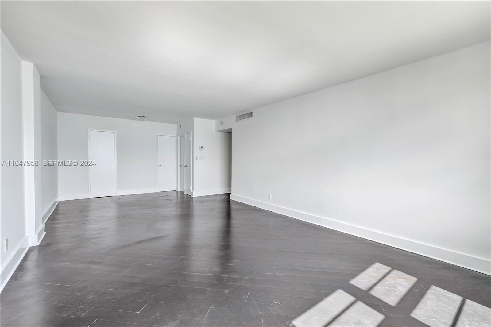 5151 Collins Avenue, Unit 1627 Miami Beach, FL 33140 - Photo 22 of 28 a view of a room with wooden floor and white walls