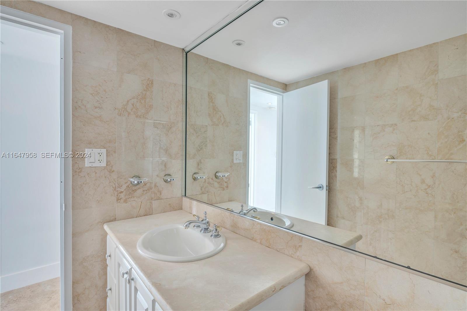 5151 Collins Avenue, Unit 1627 Miami Beach, FL 33140 - Photo 23 of 28 a bathroom with a sink and a mirror