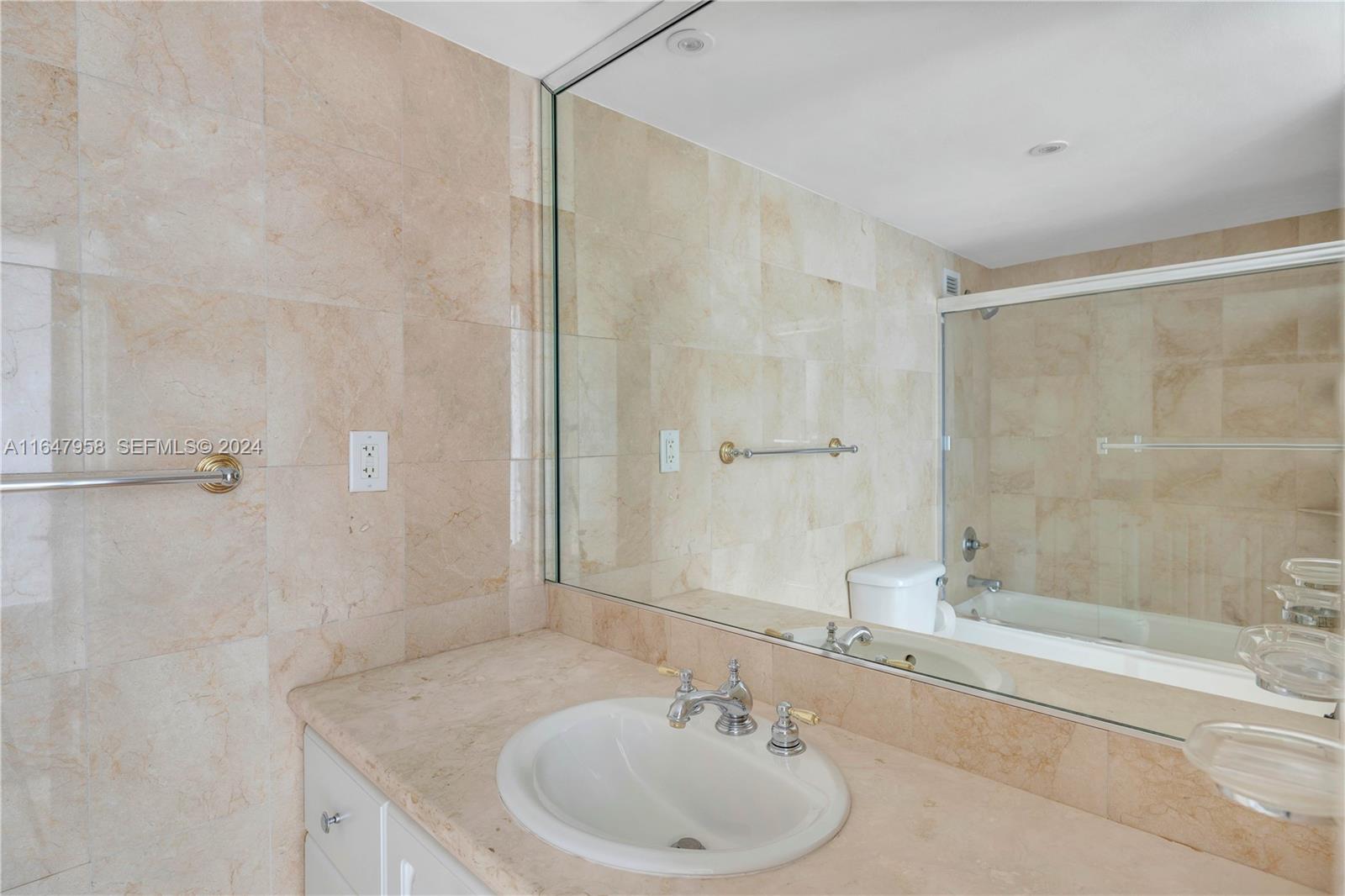 5151 Collins Avenue, Unit 1627 Miami Beach, FL 33140 - Photo 24 of 28 a bathroom with a sink and a mirror