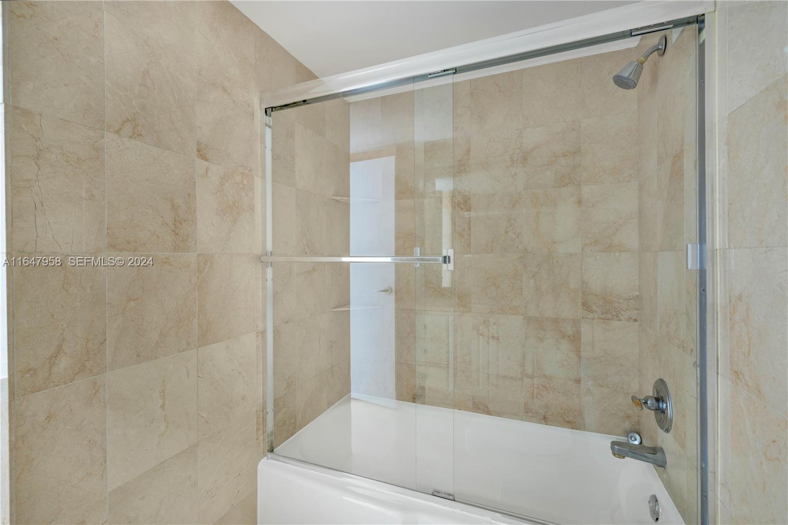 5151 Collins Avenue, Unit 1627 Miami Beach, FL 33140 - Photo 25 of 28 a bathroom with a shower and a bath tub