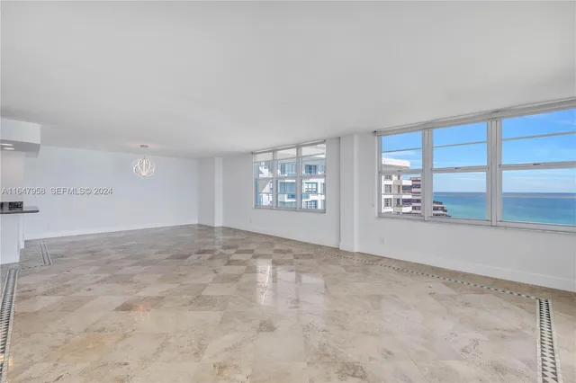 a kitchen with kitchen island granite countertop a sink white cabinets and white appliances
