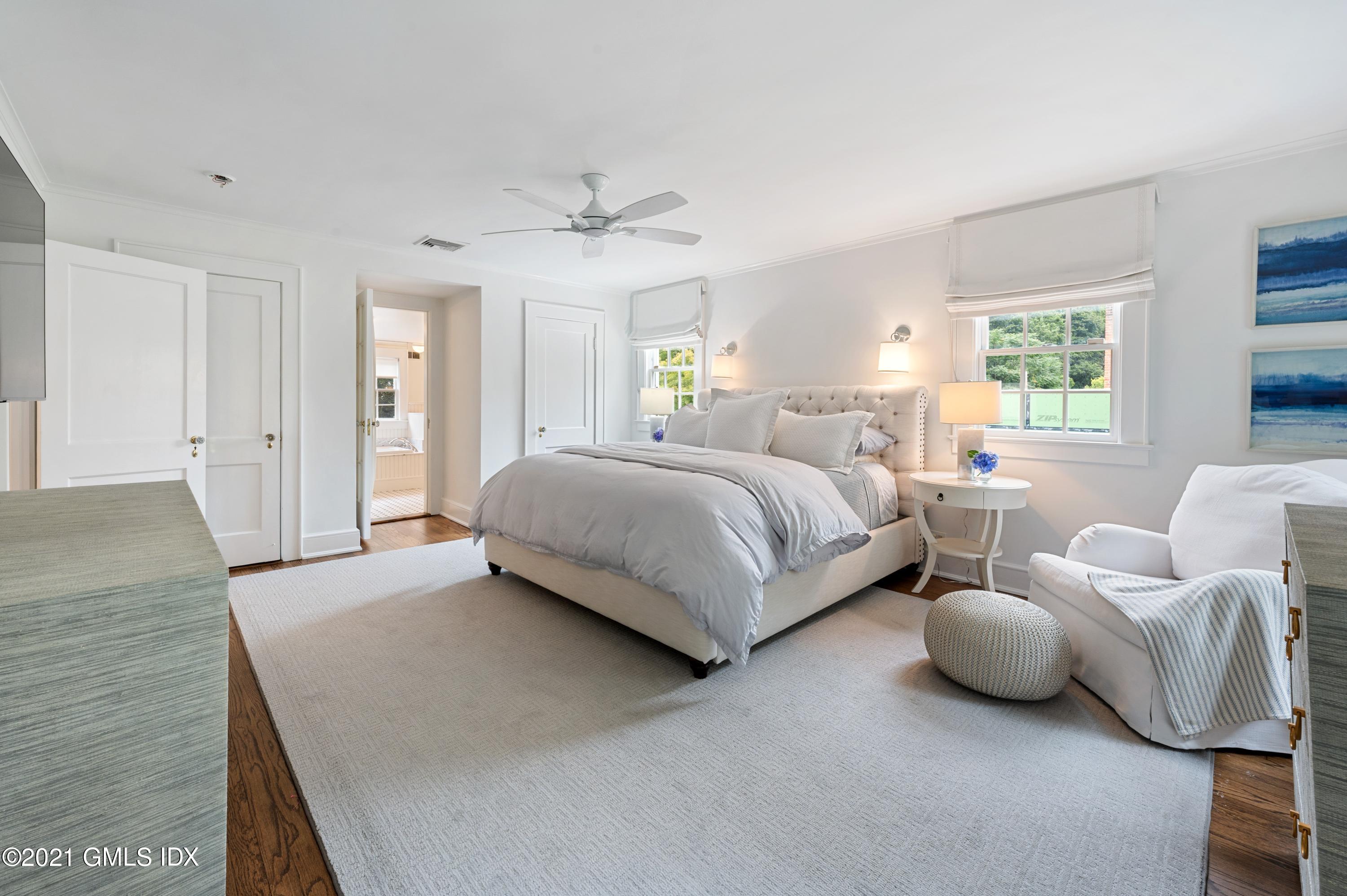 32 Perryridge Road Greenwich, CT 06830 - Photo 13 of 29 a spacious bedroom with a bed and a chandelier