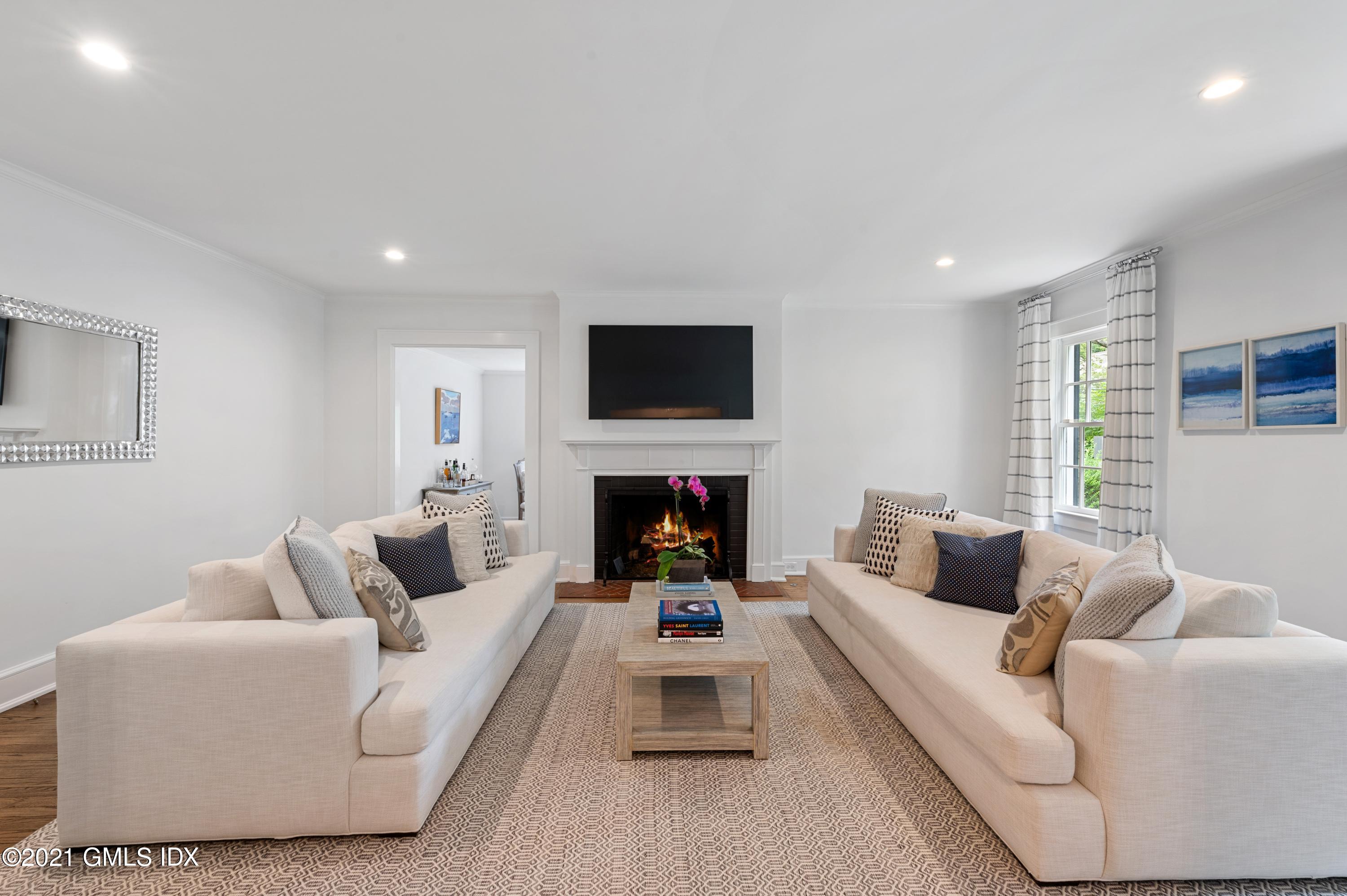 32 Perryridge Road Greenwich, CT 06830 - Photo 3 of 29 a living room with furniture a fireplace and a flat screen tv
