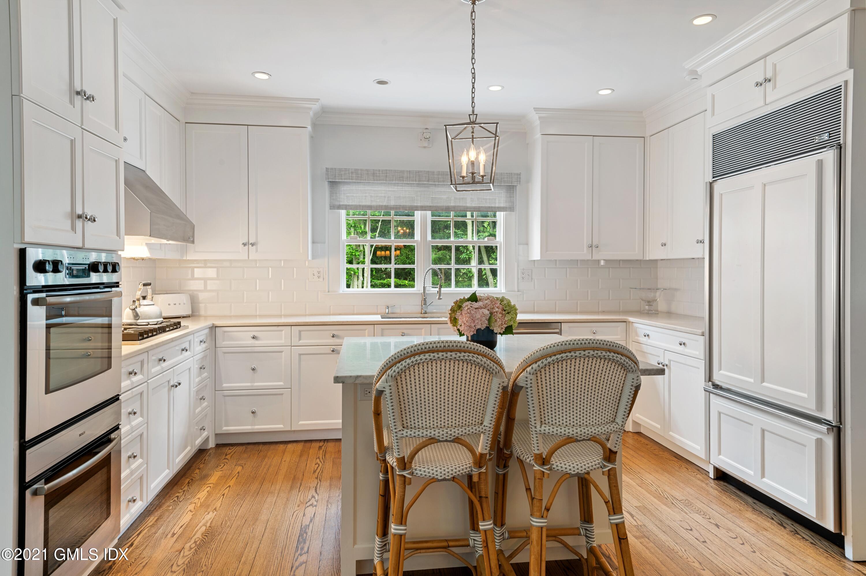 32 Perryridge Road Greenwich, CT 06830 - Photo 8 of 29 a kitchen with stainless steel appliances granite countertop a stove a refrigerator and wooden cabinets