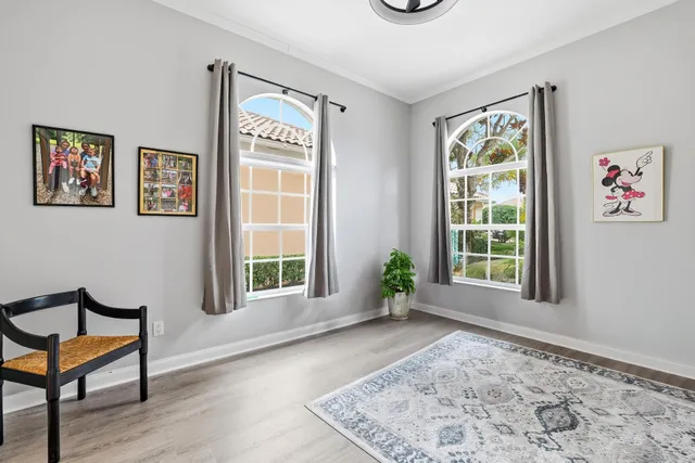 a view of an empty room with window and hardwood