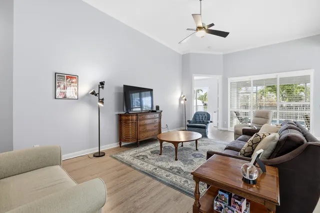 a living room with furniture a ceiling fan and a window