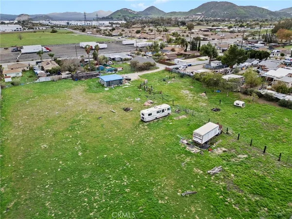 an aerial view of a residential houses with outdoor space and trees