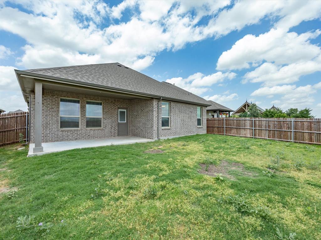 1121 Knightsbridge Road Argyle, TX 76226 - Photo 37 of 39 Spacious backyard featuring a covered concrete patio, brick exterior, multiple windows, and a wood privacy fence