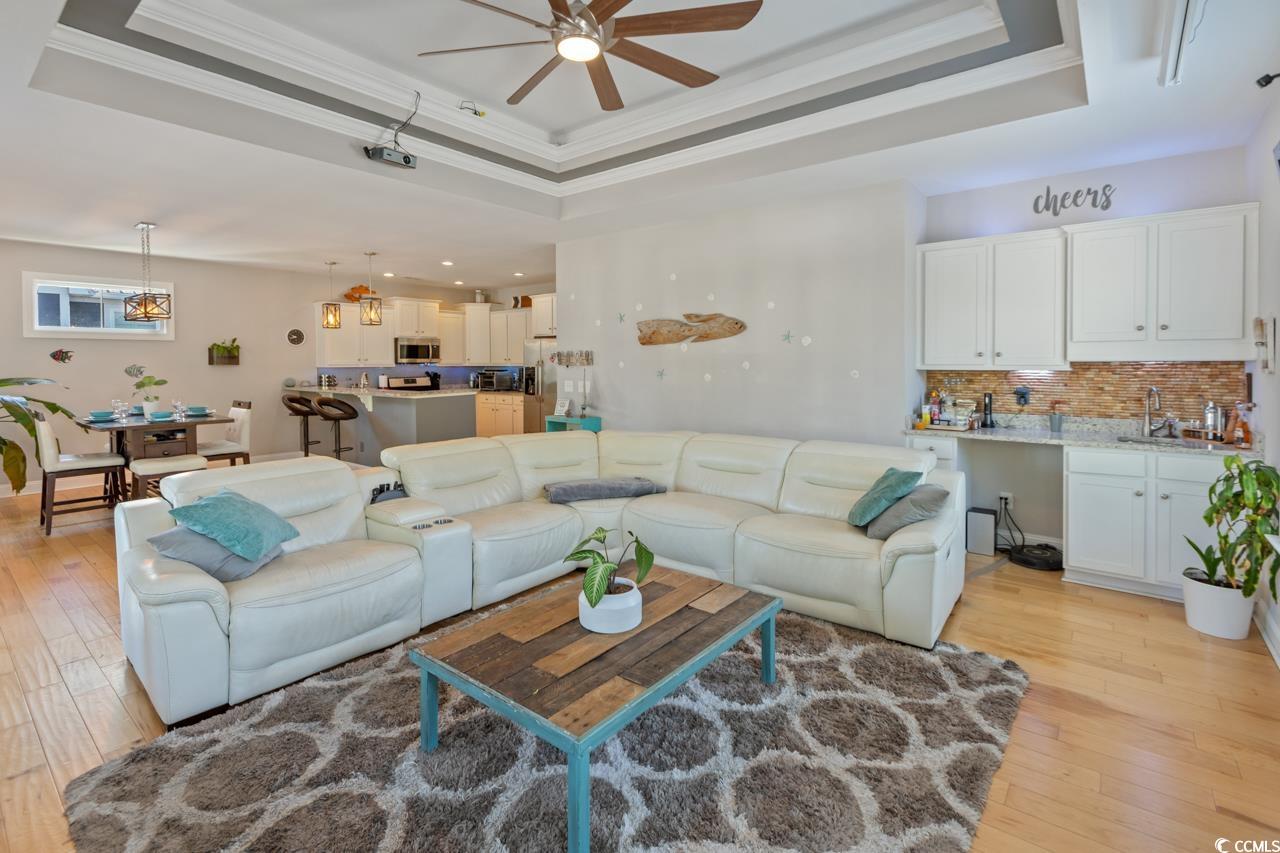 3887 Spanner Way Murrells Inlet, SC 29576 - Photo 6 of 32 Living room with a tray ceiling, crown molding, and light wood finished floors