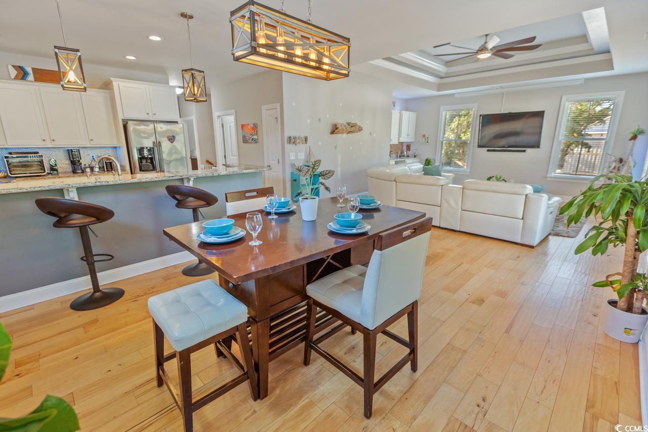 3887 Spanner Way Murrells Inlet, SC 29576 - Photo 8 of 32 Dining area with light wood finished floors, a tray ceiling, and ceiling fan