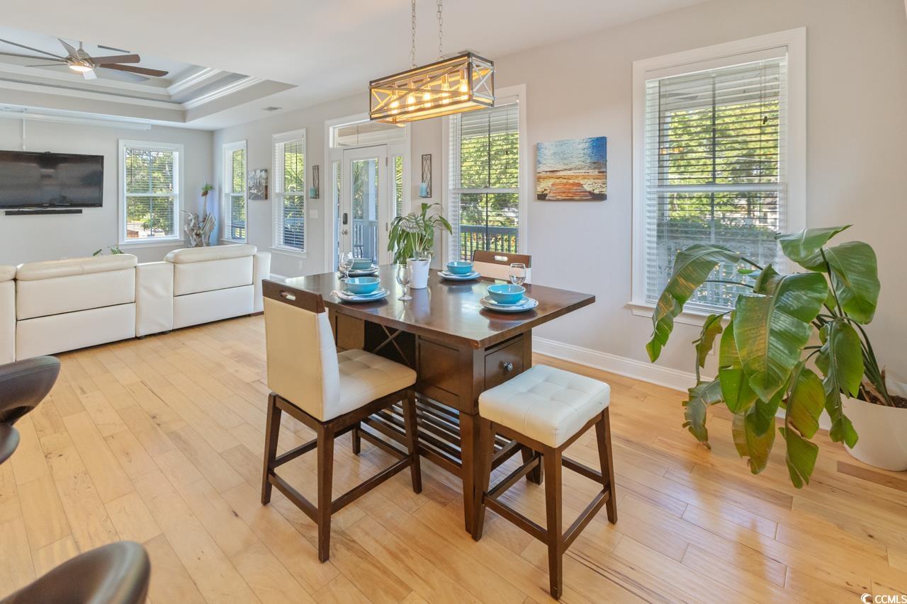 3887 Spanner Way Murrells Inlet, SC 29576 - Photo 9 of 32 Dining room featuring a tray ceiling, light wood-style floors, plenty of natural light, and crown molding