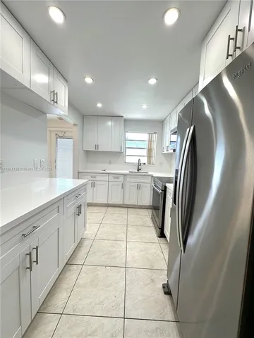a kitchen with stainless steel appliances granite countertop a refrigerator and a sink