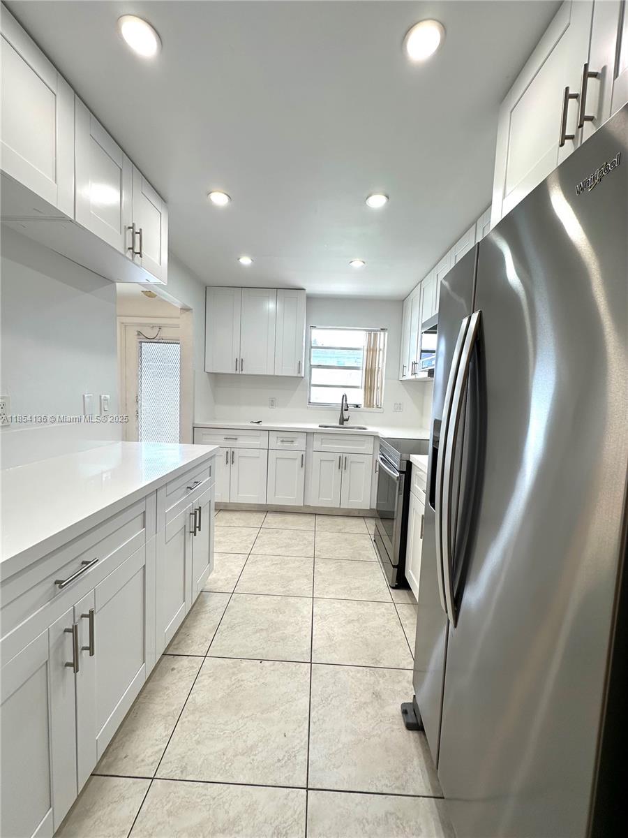 603 South State Road 7, Unit 1D Margate, FL 33068 - Photo 2 of 12 a kitchen with stainless steel appliances granite countertop a refrigerator and a sink