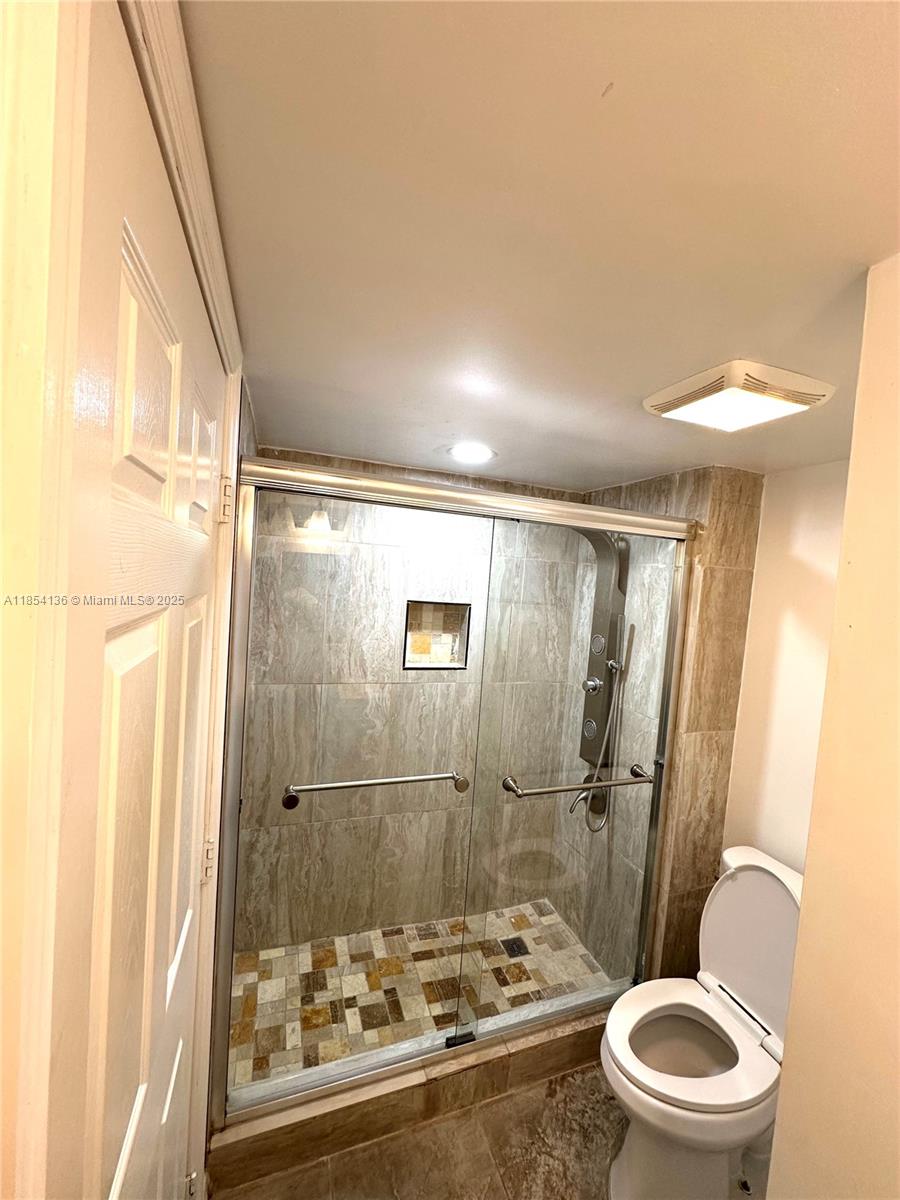 603 South State Road 7, Unit 1D Margate, FL 33068 - Photo 8 of 12 a bathroom with a sink a toilet a mirror and a shower