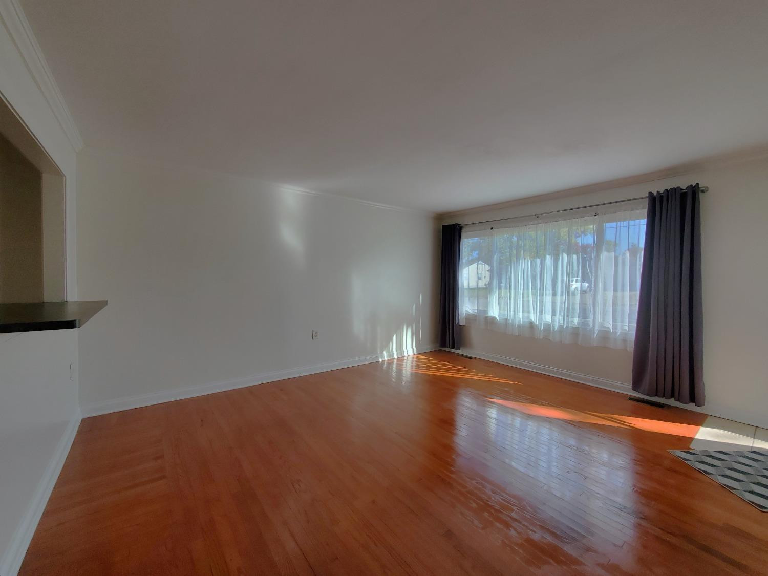 722 Fremont Road Valparaiso, IN 46385 - Photo 2 of 17 a view of an empty room with wooden floor and a window