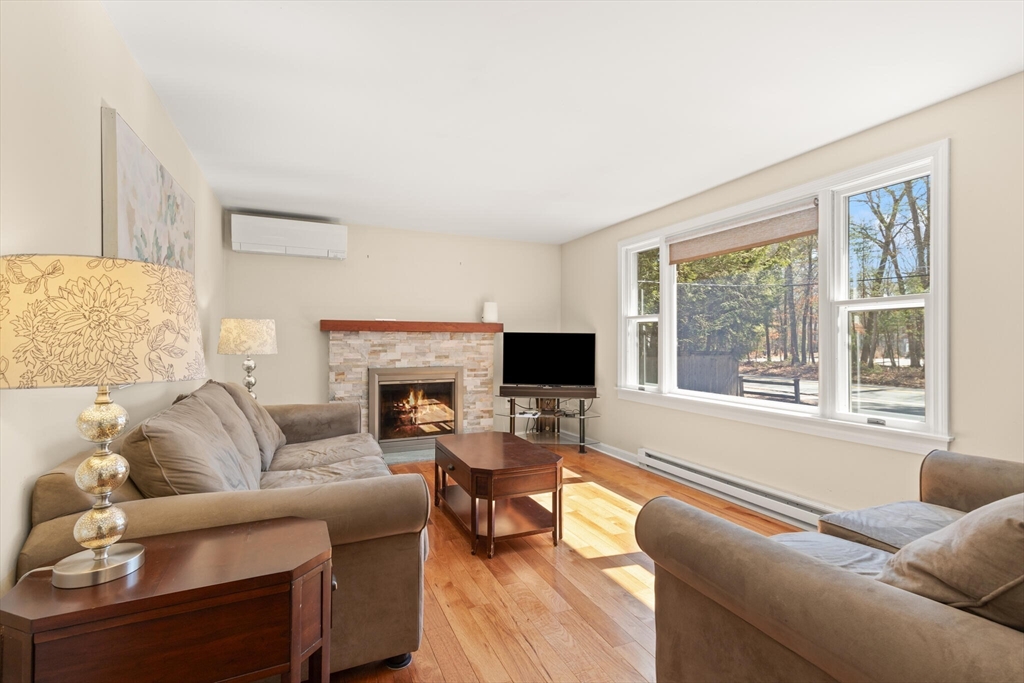 552 Hudson Road Sudbury, MA 01776 - Photo 4 of 19 a living room with furniture a large window and a fireplace