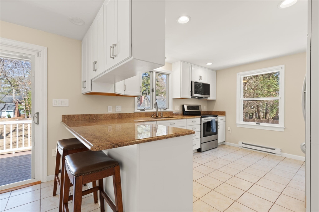 552 Hudson Road Sudbury, MA 01776 - Photo 7 of 19 a kitchen with granite countertop a stove a sink and a microwave