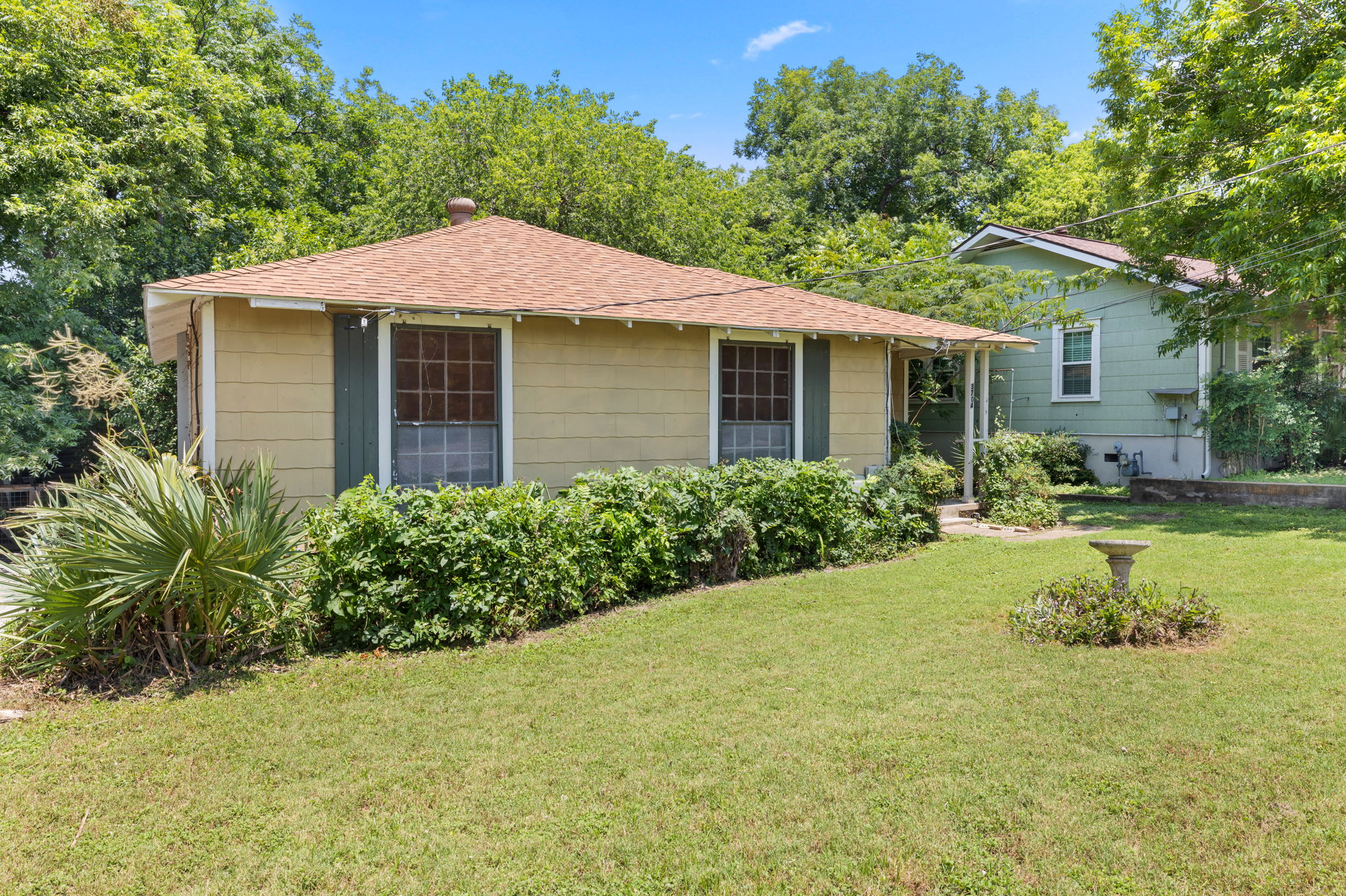 3704 Cherrywood Road Austin, TX 78722 - Photo 2 of 40 A mid century home with mature landscaping and a well-kept lawn awaits its new owner.