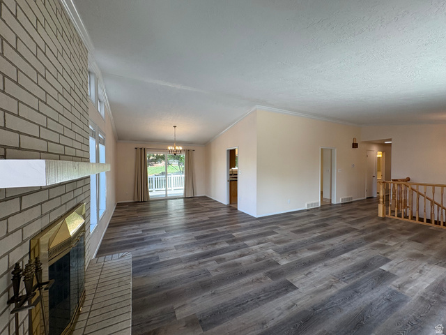 595 Meadowlark Road Orem, UT 84097 - Photo 5 of 87 Spacious interior featuring wide plank wood-finish flooring, a brick fireplace with a white mantel, and ample natural light from multiple windows