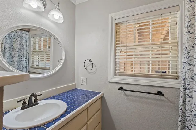 a bathroom with a sink a mirror and a window
