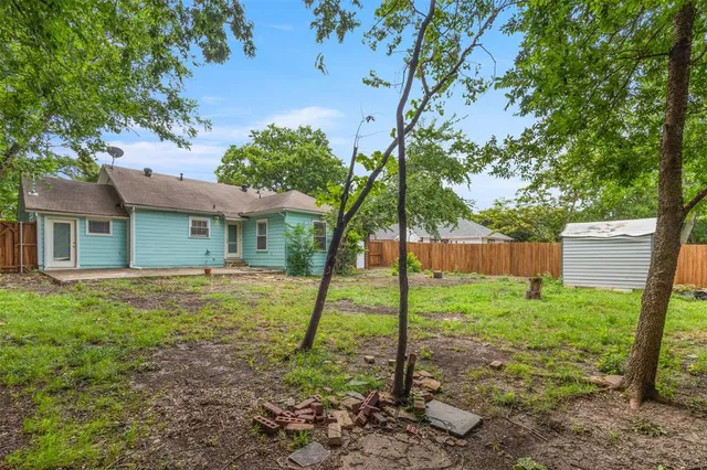 a backyard of a house with a table and chairs