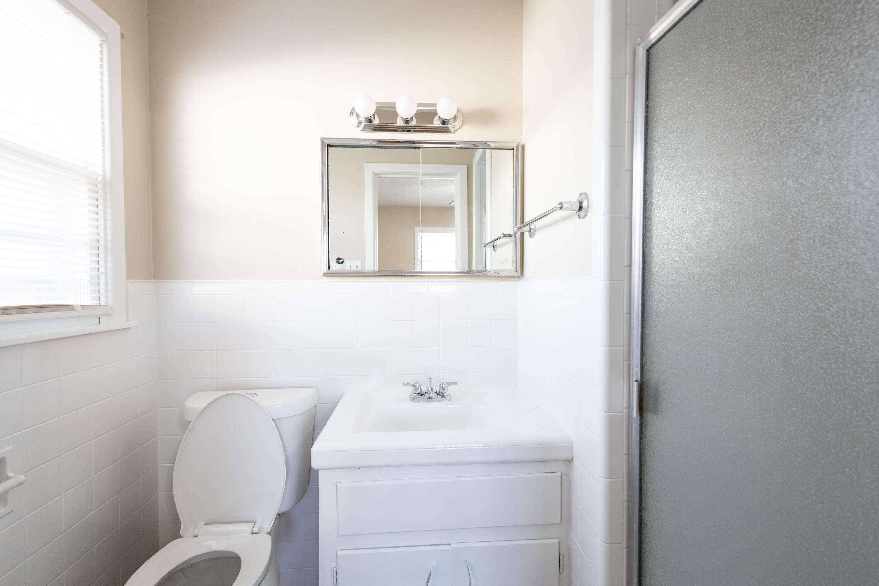 5323 31st Street Lubbock, TX 79407 - Photo 15 of 28 a bathroom with a toilet sink and mirror