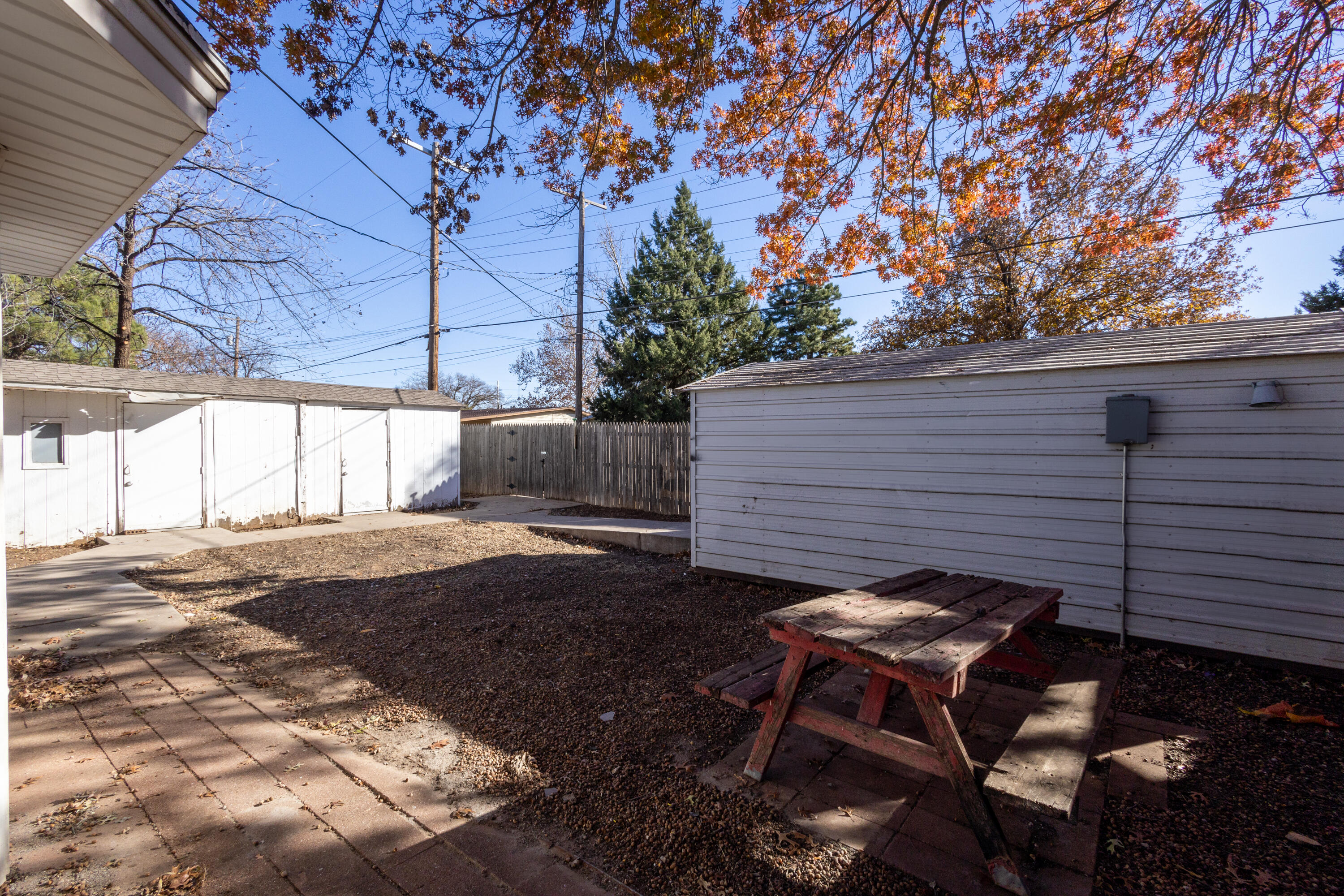 5323 31st Street Lubbock, TX 79407 - Photo 26 of 28 a backyard of a house with table and chairs under an umbrella