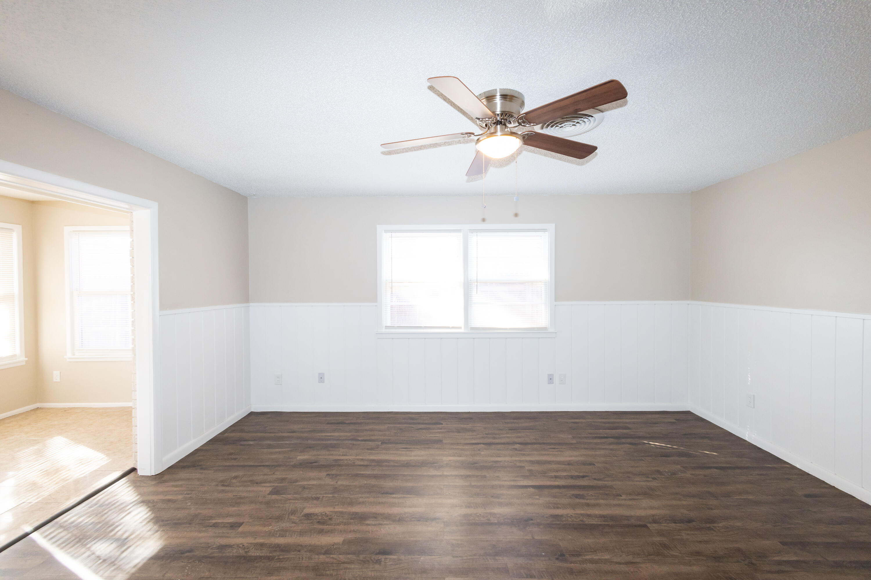 5323 31st Street Lubbock, TX 79407 - Photo 5 of 28 an empty room with wooden floor fan and windows
