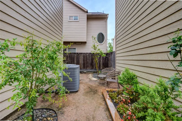 a view of a backyard with plants and brick wall