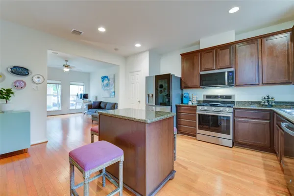 a kitchen with stainless steel appliances granite countertop a refrigerator stove top oven and sink