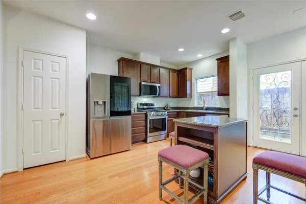 a kitchen with a refrigerator a stove top oven and a center island