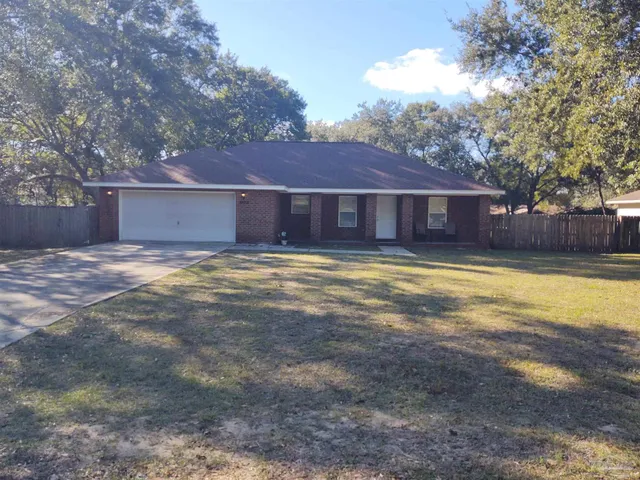 a view of a house with a yard and large tree