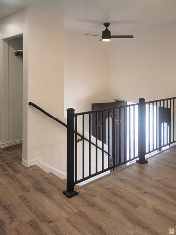 1510 South Lawrence Road Huntington, UT 84528 - Photo 2 of 16 Upper-level landing featuring wood-finish flooring, a black metal railing, and a contemporary ceiling fan with integrated lighting